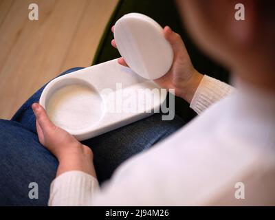 persona adulta che maneggia il nuovo prodotto mentre lo tiene in mano, vista orizzontale ravvicinata Foto Stock