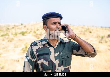 Felice soldato indiano in uniforme parlando con la famiglia - concetto di servizio in servizio, comunicazione e miising famiglia o amici Foto Stock