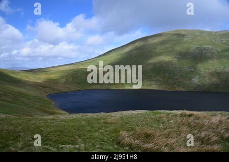 Glacial Grisedale Tarn si trova nelle colline circostanti di alto livello nelle campane del Lake District. Foto Stock