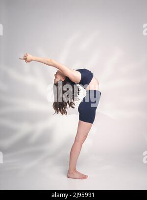 Una giovane donna cacucasiana, che esercita yoga in varie posizioni e asanas. Girato in studio su sfondo bianco. Foto Stock