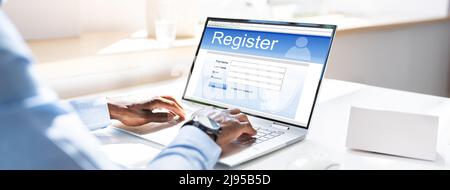 Businessman's Hand Filing Online modulo di registrazione su laptop in Office Foto Stock