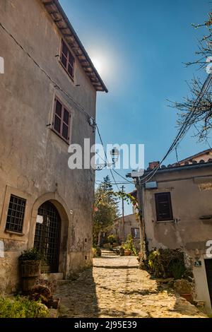 Il piccolo borgo di Tolfa, in Lazio. Uno sguardo della città con le sue vecchie case in pietra e mattoni e vicoli acciottolati. Foto Stock