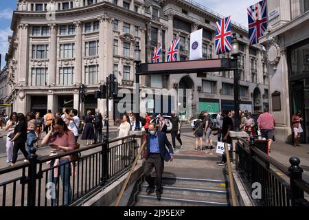 Union Flags si aggrappa al di sopra di Oxford Circus mentre gli amanti dello shopping, i visitatori e i londinesi passeranno per celebrare il prossimo Platinum Jubilee della Regina Elisabetta IIS il 17th maggio 2022 a Londra, Regno Unito. Nel 2022, sua Maestà la Regina Elisabetta II diventerà il primo monarca britannico a celebrare un Giubileo del platino per celebrare il 70th anniversario della sua adesione al trono il 6 febbraio 1952. Oxford Street è un importante centro commerciale nel West End della capitale ed è la via dello shopping più trafficata di Europes con circa mezzo milione di visitatori giornalieri ai suoi circa 300 negozi, la maggior parte dei quali sono Foto Stock