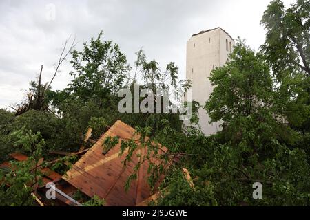 Lippstadt, Germania. 20th maggio 2022. La guglia della chiesa cattolica di San Clemente a Hellinghausen vicino Lippstadt è completamente distrutta e si trova di fronte alla chiesa. Un presunto tornado ha causato danni enormi a Lippstadt il venerdì pomeriggio. Credit: Friso Gentsch/dpa/Alamy Live News Foto Stock