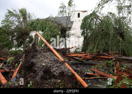 Lippstadt, Germania. 20th maggio 2022. I detriti si trovano di fronte alla Chiesa cattolica di San Clemente a Hellinghausen, vicino a Lippstadt, la cui guglia è stata distrutta. Un presunto tornado ha causato danni enormi a Lippstadt il venerdì pomeriggio. Credit: Friso Gentsch/dpa/Alamy Live News Foto Stock