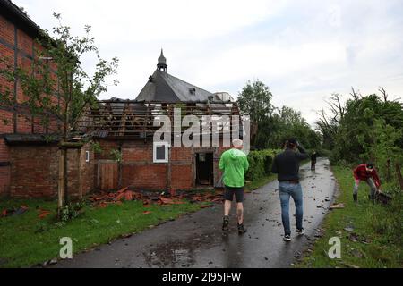 Lippstadt, Germania. 20th maggio 2022. Persone in piedi di fronte a una casa danneggiata. Un presunto tornado ha causato danni enormi a Lippstadt il venerdì pomeriggio. Credit: Friso Gentsch/dpa/Alamy Live News Foto Stock