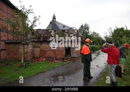 Lippstadt, Germania. 20th maggio 2022. Persone in piedi di fronte a una casa danneggiata. Un presunto tornado ha causato danni enormi a Lippstadt il venerdì pomeriggio. Credit: Friso Gentsch/dpa/Alamy Live News Foto Stock