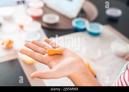 Le bambine scolpiscono le figurine di artigianato da aria plastilina, modeling pasta.Online lezioni in tablet. Creatività dei bambini,hobby,attività di sviluppo,t Foto Stock