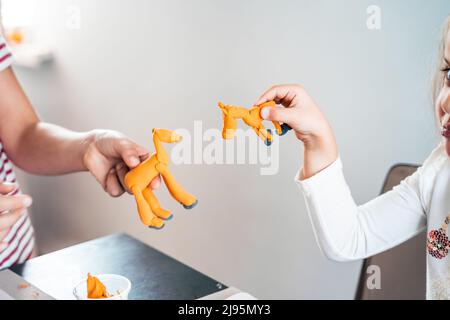 Le bambine scolpiscono le figurine di artigianato da aria plastilina, modeling pasta.Online lezioni in tablet. Creatività dei bambini,hobby,attività di sviluppo,t Foto Stock