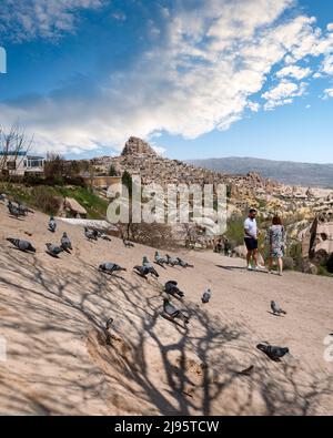 Nevsehir, Turchia - Aprile 24 2022: I turisti godono Pigeon Valley con vicino Castello di Uchisar. Foto Stock