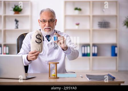 Medico anziano in concetto di remunerazione Foto Stock