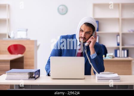 Giovane impiegato di uomini d'affari che soffre di mal di denti sul posto di lavoro Foto Stock