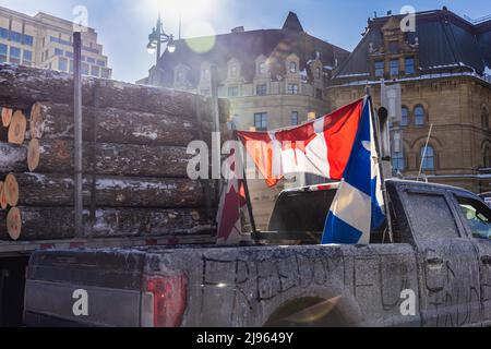 Un camion sporco centro in una città canadese con la parola libertà e bandiera nazionale durante la protesta contro i mandati di Covid 19, sfondo sfocato città. Foto Stock