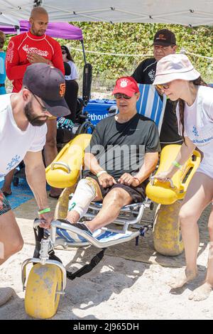 Miami Beach Florida, Sabrina Cohen Adaptive Beach Day, disabili esigenze speciali disabili waterwheels galleggianti sedia a rotelle, uomo nero donna maschio vo Foto Stock