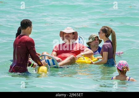 Miami Beach Florida, Sabrina Cohen Adaptive Beach Day, disabili esigenze speciali disabili waterwheels galleggianti sedia a rotelle, uomo maschio donna volontariamente Foto Stock