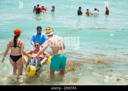 Miami Beach Florida, Sabrina Cohen Adaptive Beach Day, disabili esigenze speciali disabili waterwheels galleggianti sedia a rotelle, uomo ispanico donna maschile Foto Stock