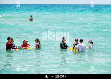 Miami Beach Florida, Sabrina Cohen Adaptive Beach Day, disabili esigenze speciali disabili waterwheels galleggianti sedia a rotelle, uomo ispanico donna maschile Foto Stock