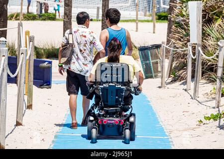 Miami Beach Florida, Sabrina Cohen Adaptive Beach Day, disabili esigenze speciali disabili tappeto rampa famiglia padre figlio madre sedia a rotelle elettrica Foto Stock