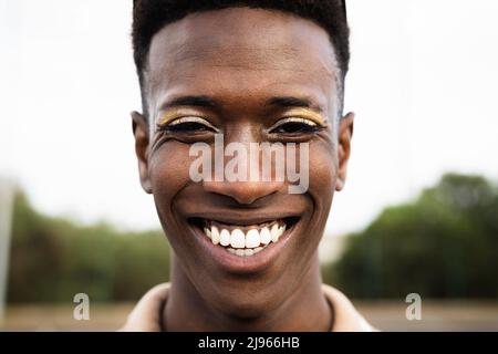 Felice gay africano che sorride davanti alla macchina fotografica Foto Stock