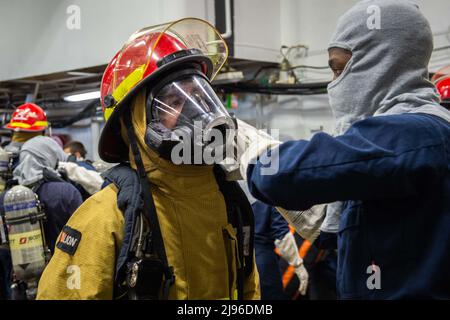 220519-N-EE352-1301 SAN DIEGO (19 maggio 2022) i marinai indossano attrezzature di protezione antincendio durante una trivella antincendio nella baia di hangar del vettore aereo di classe Nimitz USS Carl Vinson (CVN 70), maggio 19. Vinson è attualmente in prima posizione nel suo homeport di San Diego. (STATI UNITI Foto Navy di SMass Communication Specialist Seaman Leon Vonguyen) Foto Stock