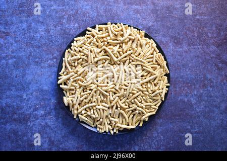 Uno spuntino indiano speziato a base di ceci fritto e fritto a base di farina di ceci Foto Stock