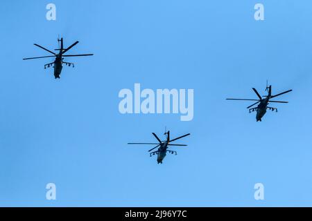 Il volo di tre elicotteri da battaglia sovietici, tipo MIL mi-24 che vola sul cielo azzurro. Foto Stock