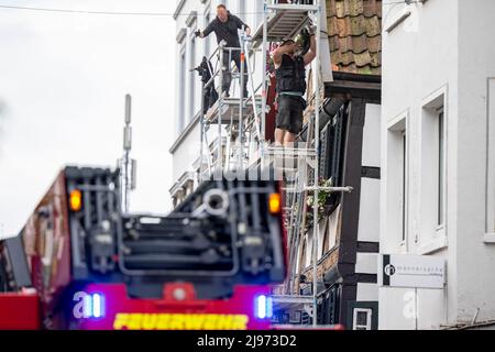 Lippstadt, Germania. 21st maggio 2022. I lavoratori rimuovono le scandole danneggiate da una casa a graticcio centro. Un giorno dopo il tornado, i lavori di pulizia sono iniziati nel centro della città. Credit: David Inderlied/dpa/Alamy Live News Foto Stock