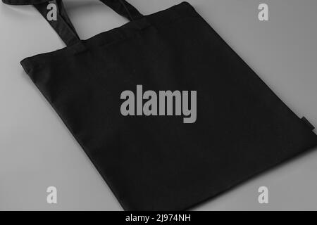 Borsa in tessuto nera vuota su sfondo grigio Foto Stock