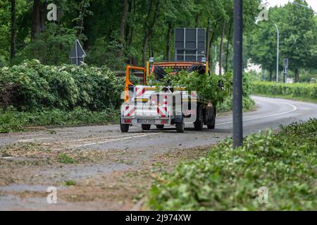 Lippstadt, Germania. 21st maggio 2022. Un veicolo proveniente dal reparto di lavori pubblici della città si trova su una strada chiusa dove foglie e rami vengono rimossi dagli alberi. Un giorno dopo il tornado, la bonifica dei danni causati dalle tempeste è iniziata nel centro della città. Credit: David Inderlied/dpa/Alamy Live News Foto Stock