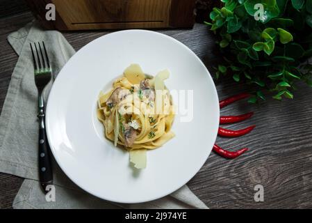 Tagliatelle cremose (fettuccini) con funghi e parmigiano Foto Stock