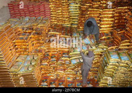 Kunduz, Afghanistan. 11th maggio 2022. I lavoratori afghani lavorano in un impianto di lavorazione del riso nella provincia di Kunduz, Afghanistan, 11 maggio 2022. Il riso e la farina di grano sono due fonti alimentari principali in Afghanistan. Più di 22 milioni su 35 milioni di abitanti si trovano ad affrontare una grave carenza di cibo. PER ANDARE CON 'caratteristica: Gli agricoltori di riso afghani lotta per alimentare la loro nazione affamata' credito: Khibar Momand/Xinhua/Alamy Live News Foto Stock