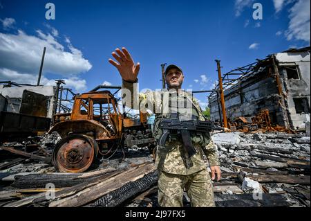 Non esclusiva: HULIAIPOLE, UCRAINA - 20 MAGGIO 2022 - Un serviceman ucraino rimane nei locali di un'impresa agricola distrutta in cenere russa Foto Stock