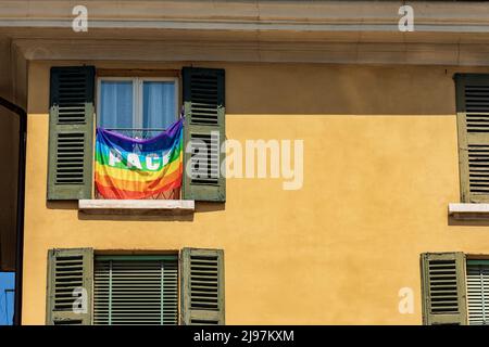 Bandiera arcobaleno con testo di pace in lingua italiana (Pace), appeso fuori da una finestra di una casa in una città italiana. Italia, Europa. Foto Stock