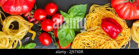 La pasta grezza con ingridients sulla lavagna nera Foto Stock