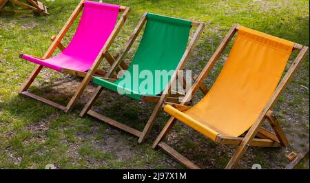 Sedie da giardino pieghevoli e colorate sul sito relax. Foto scattata in una giornata di sole. Oggetti in una posizione ombreggiata Foto Stock