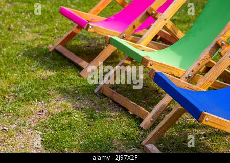 Sedie da giardino pieghevoli e colorate sul sito relax. Foto scattata in una giornata di sole. Oggetti in una posizione ombreggiata Foto Stock