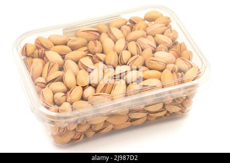 Pistacchio impaccato nocciole isolato su sfondo bianco. Dadi organici. Primo piano Foto Stock