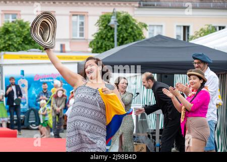 Ostritz, Germania. 21st maggio 2022. Una donna balla con un cappello in mano e tiene la bandiera dell'Ecuador alla sfilata di moda, che ha il tema della democrazia, del cosmopolitismo e della tolleranza. Il Festival della Pace è stato parte integrante della comunità per anni per contrastare gli eventi orientati alla destra nella città. Credit: Daniel Schäfer/dpa/Alamy Live News Foto Stock