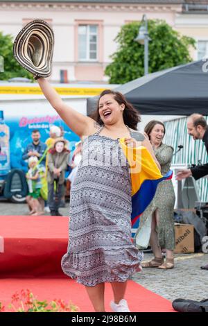 Ostritz, Germania. 21st maggio 2022. Una donna balla con un cappello in mano e tiene la bandiera dell'Ecuador alla sfilata di moda, che ha il tema della democrazia, del cosmopolitismo e della tolleranza. Il Festival della Pace è stato parte integrante della comunità per anni per contrastare gli eventi orientati alla destra nella città. Credit: Daniel Schäfer/dpa/Alamy Live News Foto Stock