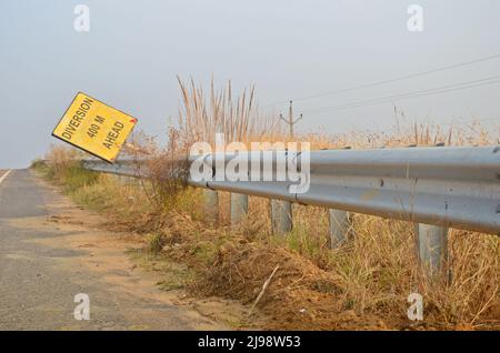 Un cartello stradale vicino a un'autostrada con barriera di sicurezza in acciaio inox. Foto Stock