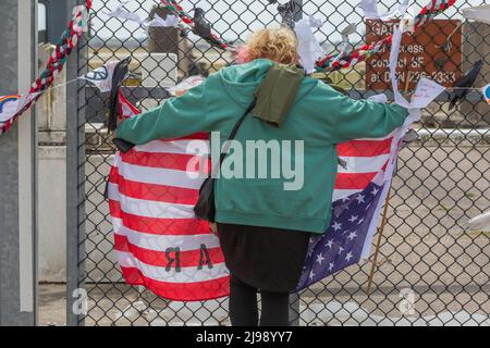 RAF Lakenheath, Suffolk, Regno Unito. 21st maggio 2022. Un manifestante si trova al confine con una bandiera americana rovesciata. Campagna per il disarmo nucleare protesta al di fuori della base aerea di Lakenheath a seguito di rapporti gli Stati Uniti si stanno preparando a mettere le armi nucleari sulla base. Penelope Barritt/Alamy Live News Foto Stock