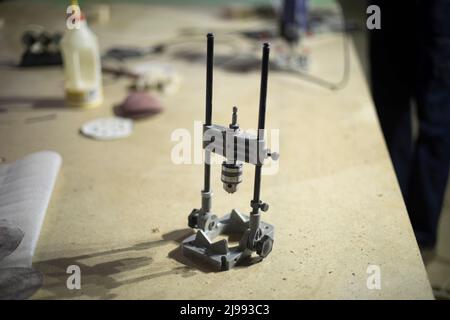 Trapano a mano sul tavolo. Attrezzi in garage. Strumento di foratura. Dettagli dell'officina di metallo. Foto Stock