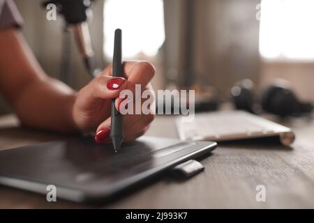 Primo piano orizzontale di una giovane donna irriconoscibile utilizzando un tablet grafico per creare arte digitale, spazio per la copia Foto Stock