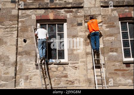 Due lavoratori lavorano in una vecchia casa a Truro, in Cornovaglia Foto Stock