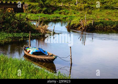 CAM Kim una piccola barca è legata tra due pali in un piccolo canale. Foto Stock