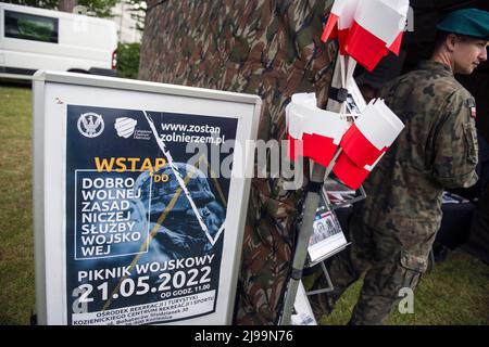 Un poster che dice Unisciti al servizio militare di base volontario è visto al picnic militare. Il reclutamento per il nuovo servizio militare generale volontario della Polonia inizia dal maggio 21st quando il governo cerca di raddoppiare le dimensioni delle sue forze armate. Il ministero della Difesa ha rivelato i dettagli sulle condizioni per il servizio di tutto l'anno, compresi i tassi di retribuzione e benefit.The introduzione del servizio militare di base volontario è stato previsto dalla legge sulla difesa della Patria, Che è stato inizialmente proposto dal governo in ottobre, ma firmato in legge poco dopo l'invasione russa dell'Ucraina. Foto Stock