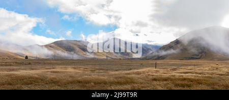 Bassa nuvola su Burkes rurale e alpino Passo panorama paesaggio di Mackenzie Paese a Canterbury Sud, Nuova Zelanda. Foto Stock