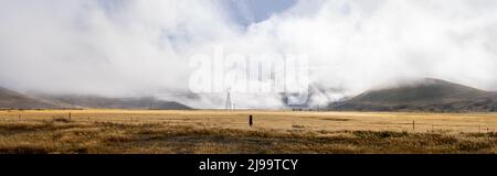 La nuvola bassa si aggira sul paesaggio rurale e alpino del Burkes Pass di Mackenzie Country a Canterbury Sud, Nuova Zelanda. Foto Stock