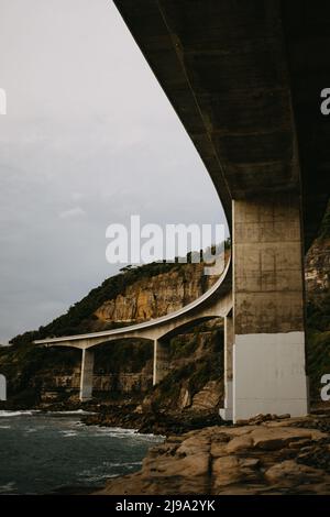 Ponte di scogliera sul bordo di ripida scogliera di arenaria sul Grand Pacific Drive lungo la costa pacifica dell'Australia, NSW Foto Stock