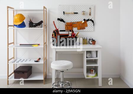 Interno della stanza con posto di lavoro, scaffale e diversi strumenti moderni Foto Stock